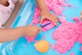 Parents and children happily play in the space sand