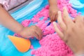 Parents and children happily play in the space sand