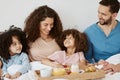 Parents, children and happy family breakfast in bed, eating food and rest together, bond and relax in apartment. Home Royalty Free Stock Photo