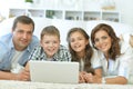 parents with children with laptops are lying on the carpet Royalty Free Stock Photo