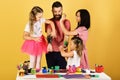 Parents and children paint on fathers arms with gouache