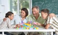 Parents and children playing with colorful plastic blocks at classroom