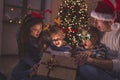 Family opening magical glowing Christmas present