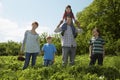 Parents and children 5-9 in a row in strawberry field Royalty Free Stock Photo