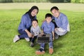 Parents and children using a laptop in the park Royalty Free Stock Photo