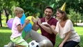 Parents congratulating son with birthday, party outside, unexpected surprise