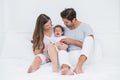 Parents with crying baby sitting on bed Royalty Free Stock Photo