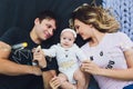 Parents cuddling baby in bed at home. Mom, dad and baby. Happy family concept. Royalty Free Stock Photo