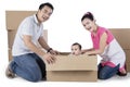 Parents and cute child playing with box Royalty Free Stock Photo
