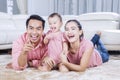 Parents and cute daughter laughing in living room