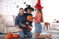 Parents and cute little girl with pumpkin having Halloween party Royalty Free Stock Photo