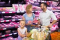 Parents with daughter choosing meat in refrigerated section in h Royalty Free Stock Photo