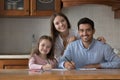 Parents and daughter drawing with pencils smile look at camera