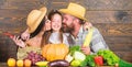 Parents and daughter harvest festival. Family farm concept. Family farmers with harvest wooden background. Grown with