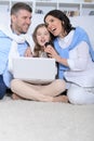 Parents and daughter singing karaoke with laptop