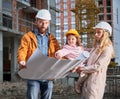 Parents with daughter studying building plan at construction site. Royalty Free Stock Photo