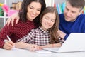 Portrait of parents and daughter using laptop in room Royalty Free Stock Photo