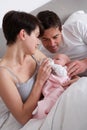 Parents Feeding Newborn Baby In Bed