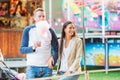 Parents at fun fair with cotton candy, watching child