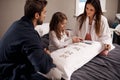 Parents, girl and child with playing cards in bedroom for bonding, learning and relax with love in house. Father, mother Royalty Free Stock Photo