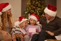 Parents, girl and children on sofa with Christmas present, surprise and happy with bonding on festive holiday. Mother