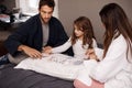 Parents, girl and fun with playing cards for game for bonding, learning and relax with strategy in bedroom. Father Royalty Free Stock Photo