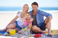 Parents, girl and sandcastle in portrait at beach, blanket and excited with hug for holiday in summer. Father, mother