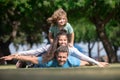 Parents giving child piggybacks in countryside. The concept of a happy family. Dream of travel.