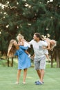 Parents Giving Children Piggybacks In Countryside enjoing time together. Happy family concept. Blurred trees background