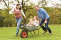 Parents Giving Children Ride In Wheelbarrow