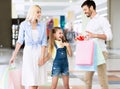 Parents Giving Daughter A Gift During Shopping In Mall