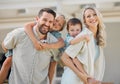 Parents giving kids piggyback rides. Family bonding outside in their yard. Parents carrying happy children. Excited kids Royalty Free Stock Photo