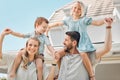 Parents giving kids piggyback rides. Family bonding outside in their yard. Parents carrying happy children. Excited kids Royalty Free Stock Photo