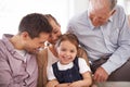 Parents, grandfather and child with portrait on sofa for healthy development, security or comfort in apartment. Family Royalty Free Stock Photo