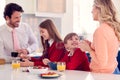 Parents Having Breakfast With Children In School Uniform At Kitchen Counter Royalty Free Stock Photo