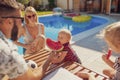 Father feeding baby boy with watermelon slice by the pool Royalty Free Stock Photo