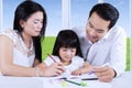 Parents help their child to write Royalty Free Stock Photo