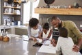 Parents Helping Children With Homework In Kitchen Royalty Free Stock Photo