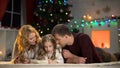 Parents helping daughter to write letter to Santa, making wishlist for Christmas