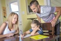 Parents helping son with homework in home interior Royalty Free Stock Photo