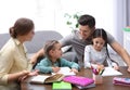 Parents helping their daughters with homework at table Royalty Free Stock Photo