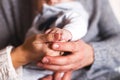 Parents hold baby`s hands close.