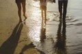 Parents are holding hands their children and walking on the beach at sunset in holiday Royalty Free Stock Photo