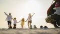 Parents are holding hands their children and walking on the beach at sunset in holiday. Royalty Free Stock Photo