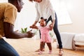 Parents At Home Encouraging Baby Daughter To Take First Steps Royalty Free Stock Photo