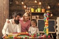 Parents hugs, watching son playing, enjoy parenthood. Family leisure concept. Kid with parents play with plastic blocks