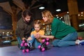 parents and injured daughter in roller skates sitting