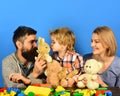 Parents and kid cuddle with toys. Family with happy faces Royalty Free Stock Photo
