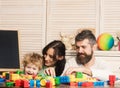 Parents and kid with happy faces make brick constructions. Royalty Free Stock Photo