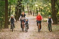 Parents and kids cycling on forest trail. family in warm clothes cycling autumn park. Family mountain bike on forest. active